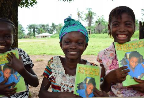 Aminata in the Middle displaying one of the text books they use for the Reading Circle.