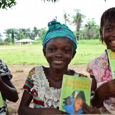 Aminata in the Middle displaying one of the text books they use for the Reading Circle.
